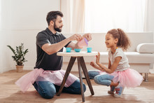 Multicultural Father And Little Daughter Having Tea Party At Home