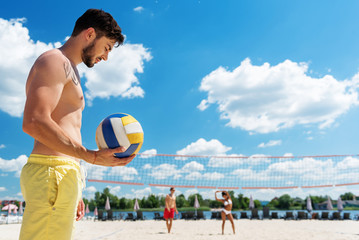 Thoughtful youthful guy with beard resting on summer beach