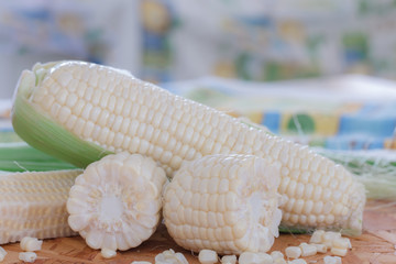 Fresh white corns on wooden table.