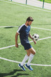 © LIGHTFIELD STUDIOS - side view of soccer player kicking ball  while training on soccer pitch