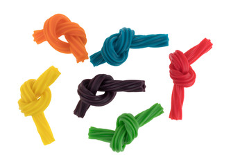 Wall Mural - Top view of colorful spiral licorice sticks tied in knots isolated on a white background.