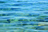 Fototapeta Fototapety z morzem do Twojej sypialni - Kolorowe kamienie i fale w przeźroczystej wodzie morza.