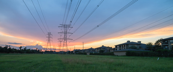 Group silhouette of transmission towers (power tower, electricity pylon, steel lattice tower) at twilight in US. Texture high voltage pillar, overhead power line, industrial background. Panorama style