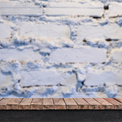 Empty wooden table with brick wall