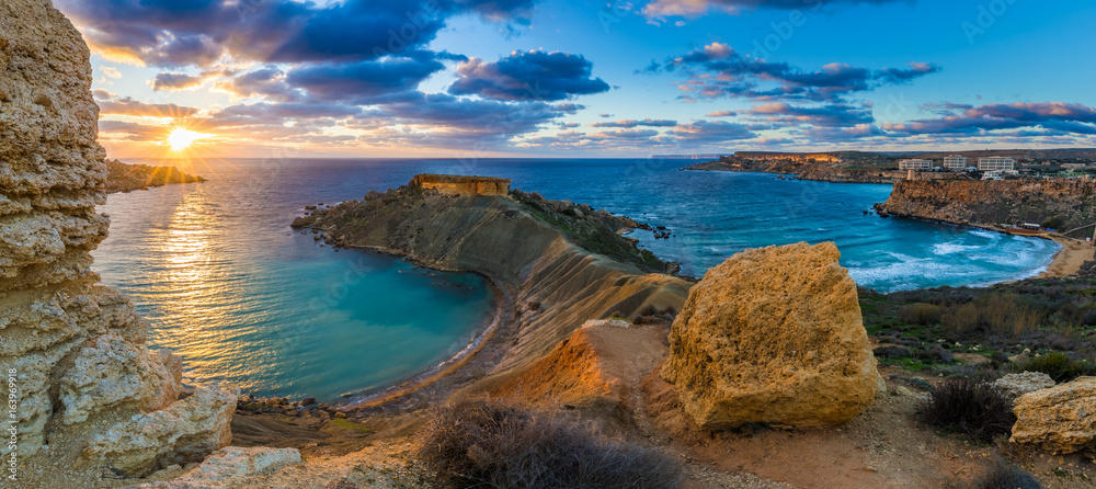 Mgarr, Malta - Panorama of Gnejna bay and Golden Bay, the two most beautiful beaches in Malta at sunset with beautiful colorful sky and golden rocks taken from Ta Lippija - obrazy, fototapety, plakaty 