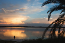 Boy Fishing At Sunset On Lake In Florida