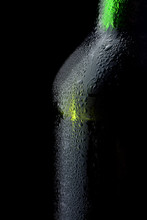 Green Bottle Of Beer, On A Black Background, With Brilliant Edges And Foam