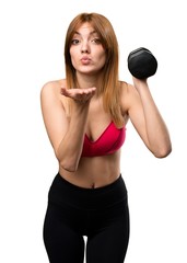 Wall Mural - Beautiful sport woman with dumbbells sending a kiss