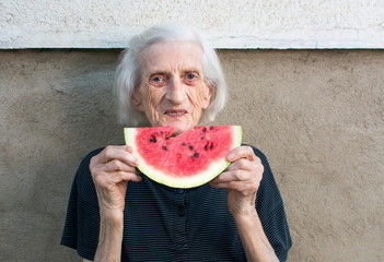 Senior woman eating watermelon outdoors