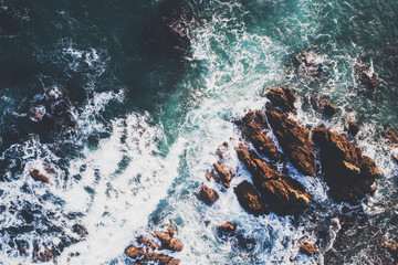 waves breaking over rocks during sunset, new zealand