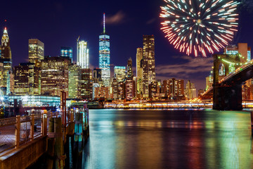 Firework over city at night with reflection in water