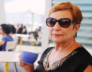 Wall Mural - Portrait of senior woman sitting in summer cafe