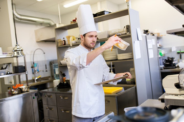 Canvas Print - chef with clipboard doing inventory at kitchen