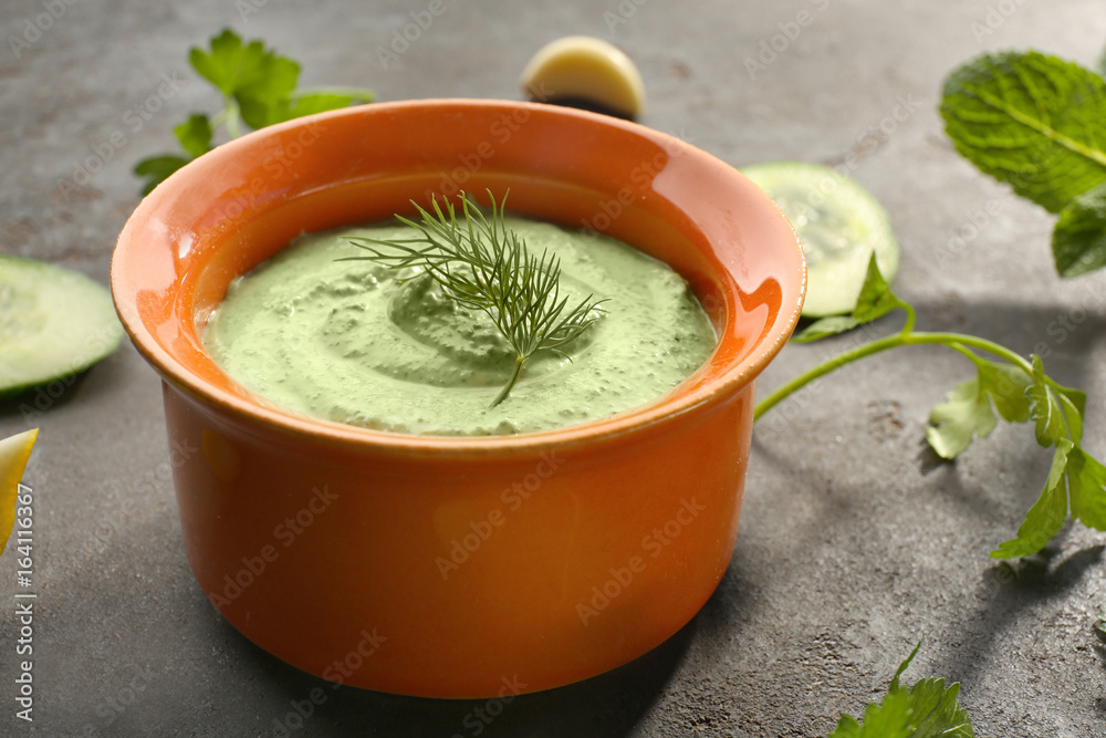 Delicious yogurt sauce in bowl on kitchen table