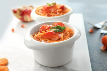 Canvas Print - Cute white bowl with yummy carrot strawberry salad on marble board