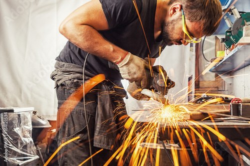 Photographie man weld in a processes a metal with a angle grinder