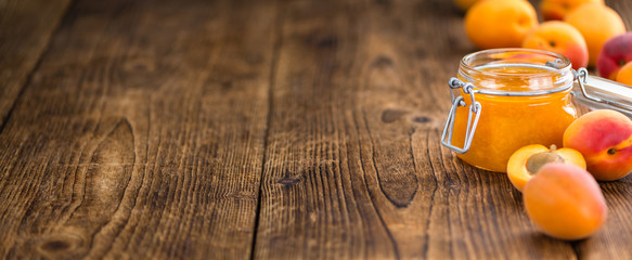 Portion of Apricot Jam on wooden background (selective focus)