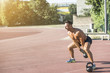 © Addoro - Crossfit training. Fitness man doing a weight training by lifting kettlebell. Midleaged athlete doing kettlebell swings. Bodybuilder lifting kettlebell. Crossfit instructor at the track.