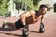 © Addoro - Crossfit training. Fitness man doing a weight training by lifting kettlebell. Midleaged athlete doing kettlebell push ups. Bodybuilder lifting kettlebell. Crossfit instructor at the track.