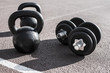 © Addoro - Close up of a kettlebell and dumbells on a running track. Sport and fitness equipment.
