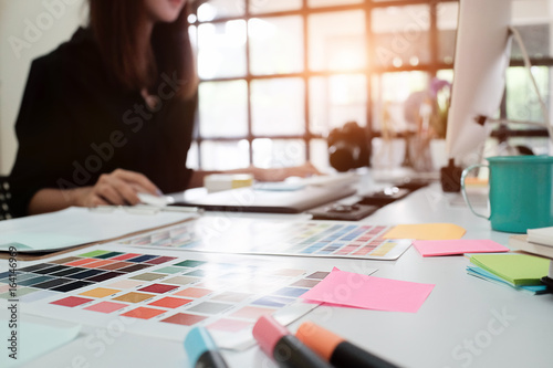 Fotografia Selective focus on creative table and woman graphic design blur in background with vintage tone