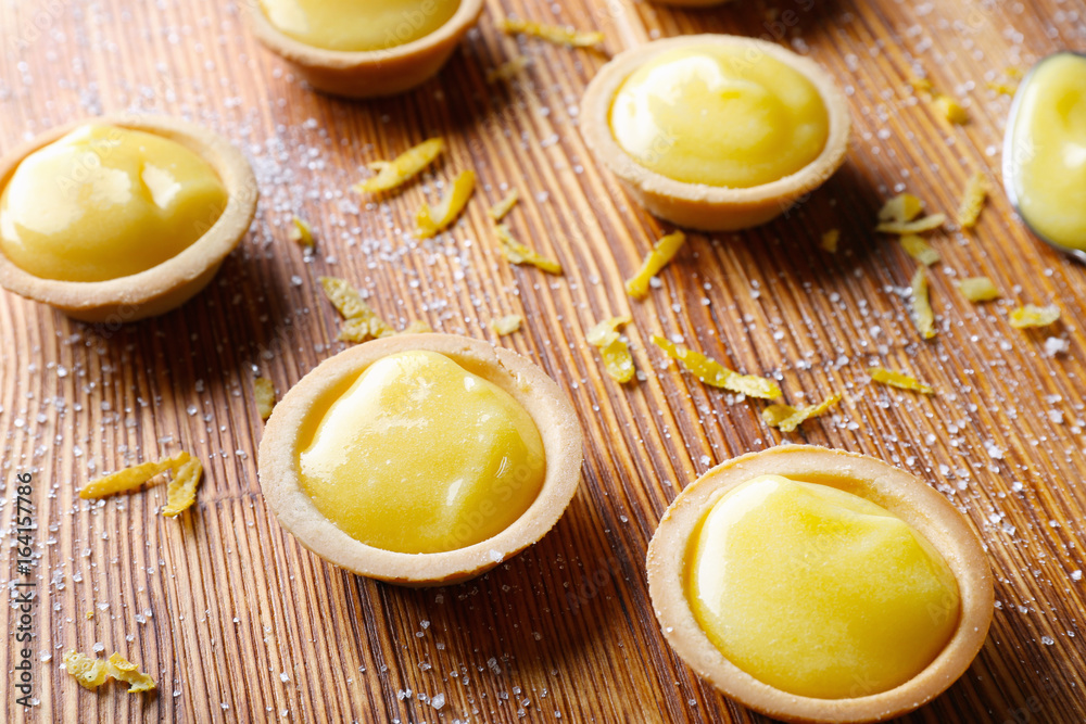 Tasty cookies with lemon curd on wooden table