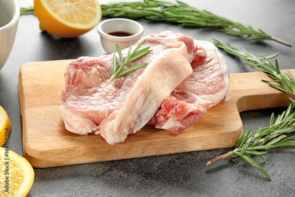 Raw steaks on wooden board