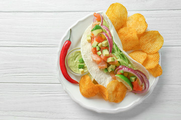 Sticker - Tasty fish taco on plate with sauce and chips on white wooden background