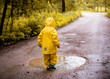 Little girl standing at a dirty puddle