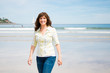 © asife - Beautiful middle aged woman walking on the beach