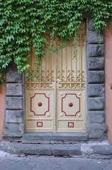 Wall Mural - Door in old Italian house with ivy on the wall