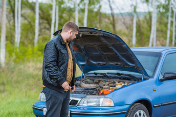 Wall Mural - Alarmed driver tries to repair the car