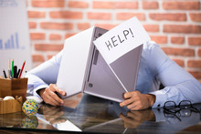 Businessman Covering His Head With Laptop Asking Help