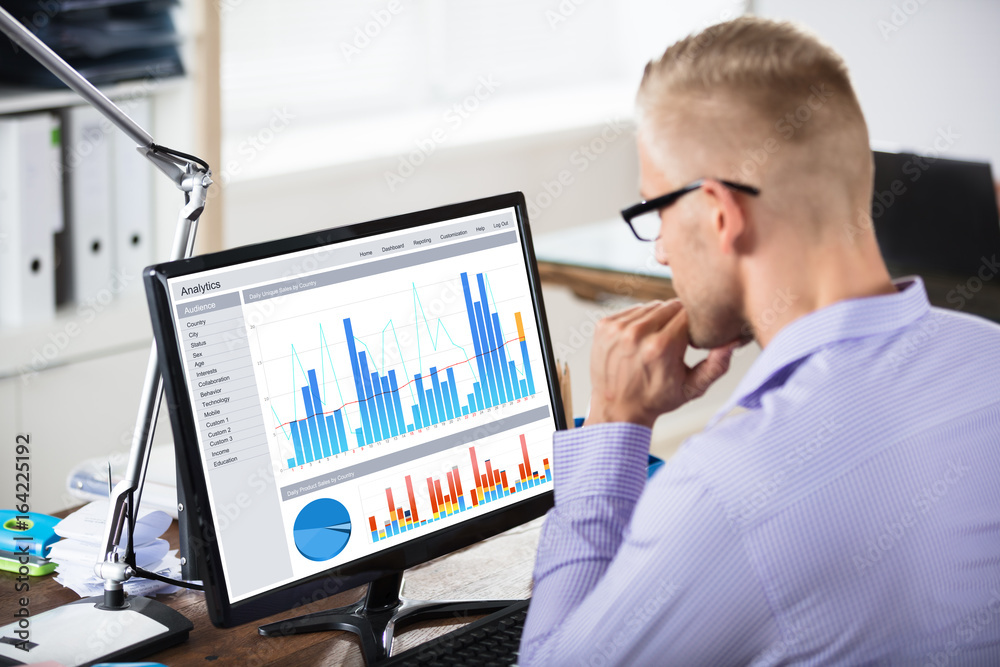 человек изучает графики на мониторе