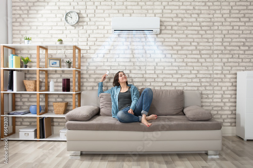 Fotografía Woman Relaxing Under The Air Conditioner