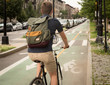 Back view of modern hipster man riding bike on bike lane in the city