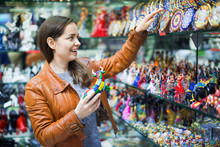 Excited Young Positive Brunette Choosing Souvenir For Memory