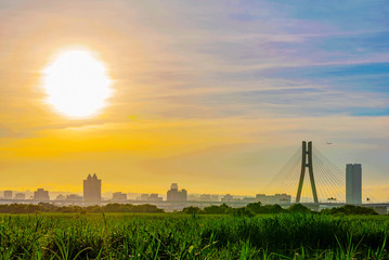 Wall Mural - Riverside view of sunset with city buildings