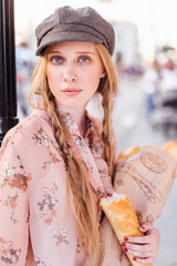 Young model stand on the street and hold bread with bike