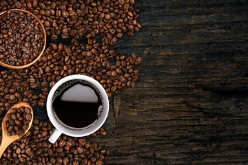 Coffee background, top view with copy space. White cup of coffee and, ground coffee, coffee beans on dark wooden background