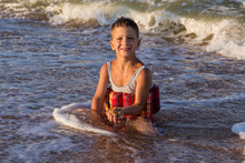 Little Boy Sitting In Sea Surf