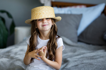 Canvas Print - Portrait of a beautiful little girl in a straw hat studio