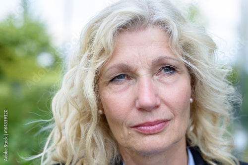 Poster Senior businesswoman standing thinking deeply