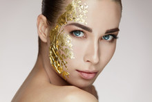 Beauty Woman Face Masking. Girl With Gold Mask On Soft Skin