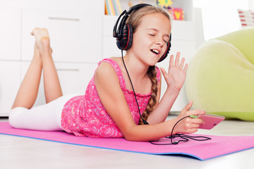 Young girl singing a tune listening to music on her phone