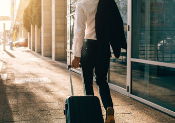 Poster - Businessman walking outside airport with suitcase