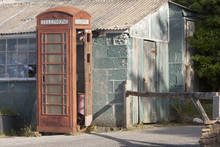 A Derelict Red Phone Box Next To A Dilapidated Building
