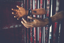 Human Hand Of Ghost Prisoner On Steel Lattice Close Up For Halloween Background. Criminal Hand Show On Steel Lattice For Help.