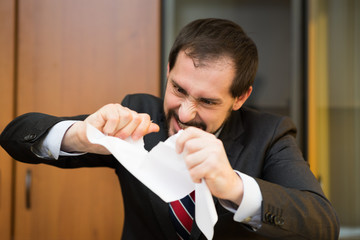 Angry man tearing apart a contract