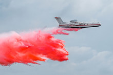 Firefighter Airplane Drops Red Water On A Fire In The Forest